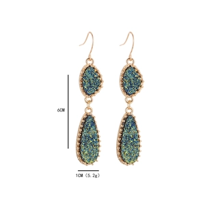 Détail des boucles d'oreilles druzy double goutte dorées mesurant 6 cm de long