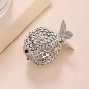 Dettaglio di un fermaglio per capelli a forma di pesce argento con strass lucidi