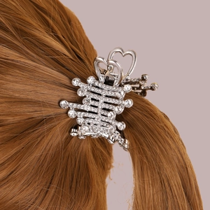 Detail of silver alloy hair claw with sparkling rhinestones and hollow heart design