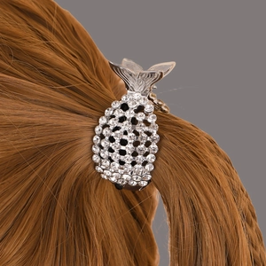 Dettaglio di una pinza per capelli a forma di ananas argento con strass sui capelli
