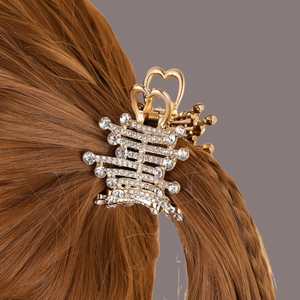 Golden hair claw clip with rhinestones for high ponytail styling on brunette hair