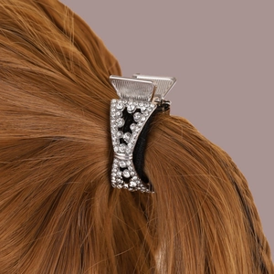 Sparkling silver metal hair claw clip with rhinestones shown on brown hair