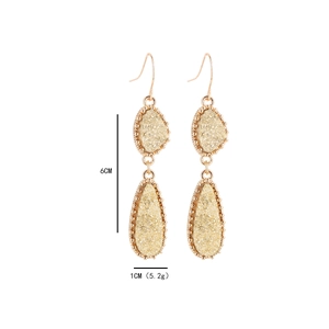 Détail des boucles d'oreilles en résine dorée avec dimensions de 6cm par 1cm