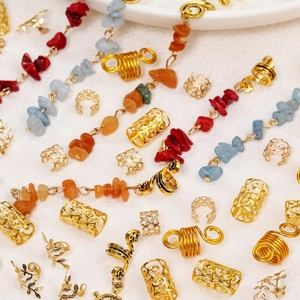 Detailed macro view of golden dreadlock beads set with natural stone charms and alloy spirals