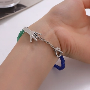 Detailed shot of an emerald green glass bead bracelet with silver chain and OT clasp