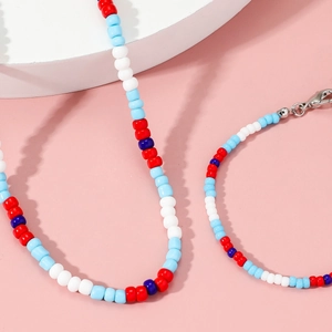 Colorful handmade glass seed bead necklace with silver lobster clasp on a pink base