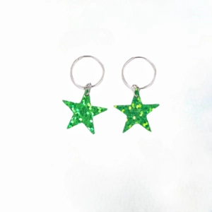 Detail of green star sequin hair rings for Y2K braids with glossy metallic finish