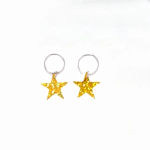 Detail of silver rings with sparkling gold glitter star pendants for Y2K hair and earrings