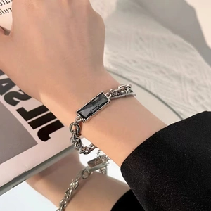 Macro detail of titanium steel chain bracelet with rectangular black gemstone on a hand