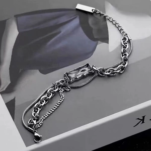 Layered titanium steel bracelet with grey zircon gemstone on fashion magazine background