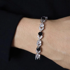 Silver tennis bracelet with alternating black and white zircon stones on model's wrist