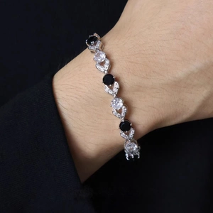 Close-up of black and white zircon stone bracelet worn on wrist with prong setting