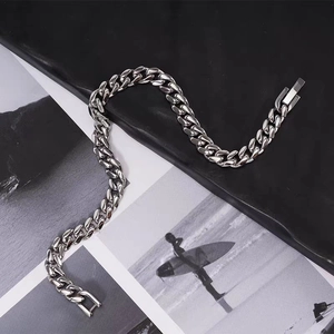 Polished titanium steel curb chain bracelet with rectangular clasp on black leather