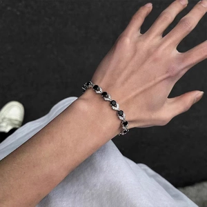 Detail of silver link bracelet with black zircon stones on a woman's wrist