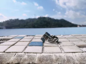 Detail of retro feather open rings with vintage oxidized finish on a tiled surface