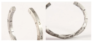 Macro detail of vintage Viking Mobius bracelet featuring engraved text and geometric patterns