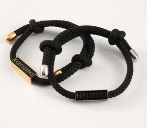 Detailansicht der gewebten Armbänder mit gold- und silbernen Confidence-Gravurplatten
