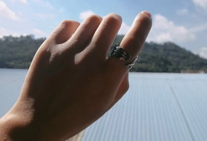 Detail of vintage silver feather open ring with intricate textures worn outdoors