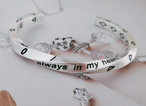 Macro shot of silver Viking Mobius bracelet engraved with 'always in my heart'