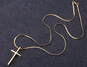Detailed view of polished gold cross pendant on a minimalist snake chain for men and women