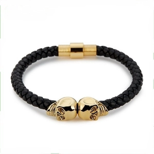 Macro shot of punk style black braided leather bracelet with golden skull details