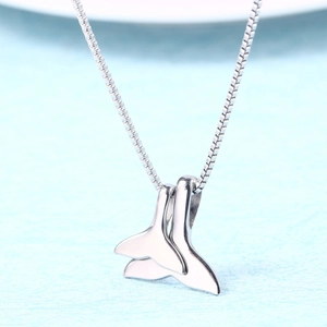 Detailed close-up of double whale tail pendants on a silver titanium steel chain