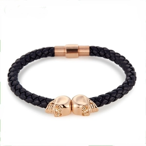 Men's punk braided leather bracelet featuring two golden skull charms and magnetic clasp