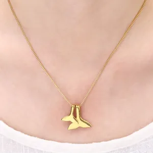 Minimalist gold double whale tail pendant necklace on elegant woman neck chain