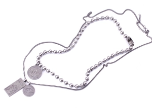 Close-up of double-layer titanium steel necklace with rectangular and round coin pendants