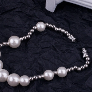 Detailed macro view of gradient pearl and silver metal beads with secure screw clasp