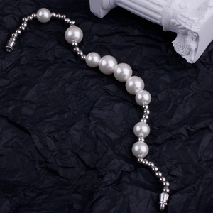 Elegant pearl bracelet with gradient white pearls and silver beads on a dark background