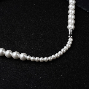 Gros plan macro sur collier de perles blanches dégradées avec intercalaires en argent