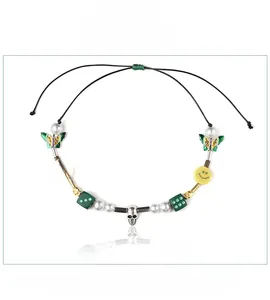 Close-up of hip hop beaded necklace with yellow smiley face and green dice pendants