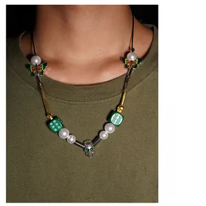 Detail of hip hop necklace featuring yellow skull, dice, and smiley face charms
