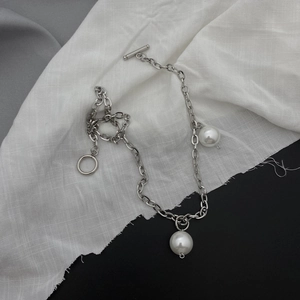 Détail du collier chaîne argentée avec deux perles blanches et fermoir à bascule OT