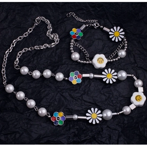 Détail du collier et bracelet en perles avec marguerite, signe de paix et smiley jaune