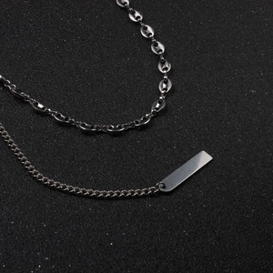 Détail d'un collier choker double couche en acier inoxydable avec maillons grains de café