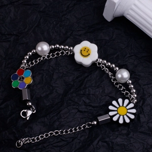 Détail du collier à perles avec breloques marguerite et smiley sur fond noir