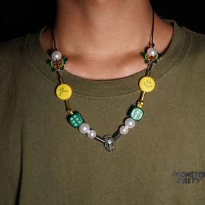 Hip hop style necklace with yellow smiley face, skull, and green dice pendants for street style