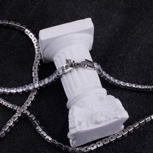 Silver tennis necklace with round cubic zirconia on a white column with black backdrop