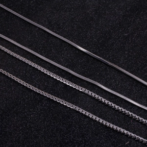 Detailed close-up showing four types of titanium steel curb and square snake chains