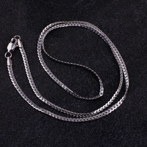 Detailed close-up of a minimalist stainless steel curb chain necklace with lobster clasp
