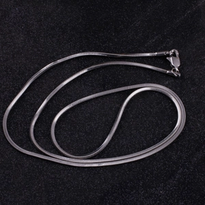 Close-up of silver steel snake chain necklace with lobster clasp on dark background
