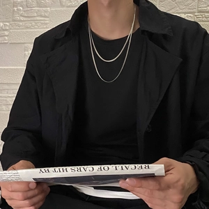 Close-up of double layer silver snake chain necklace on male model with black coat