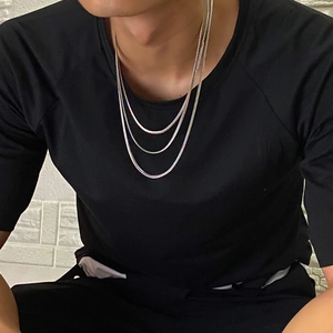 Detail of triple-layered silver titanium steel square snake chain necklace on model