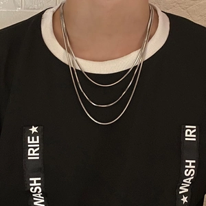 Detail of silver triple-layered thin snake chain necklace worn on a model's neck