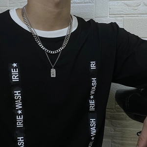 Vue détaillée du collier double chaîne argentée avec pendentif rectangulaire en relief