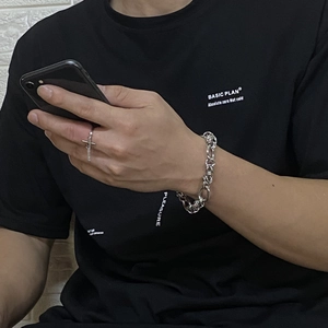 Silver chain bracelet and cross pendant ring worn by model in a daily casual style