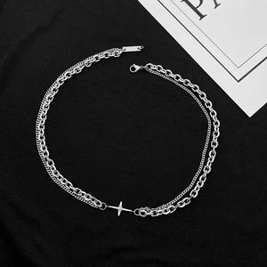 Détail d'un collier double épaisseur en acier titane argenté avec pendentif étoile et fermoir