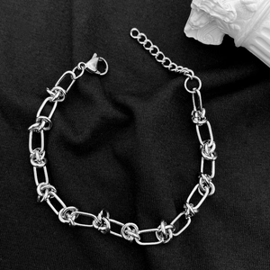Macro detail of silver titanium steel chain bracelet with knot link and lobster clasp